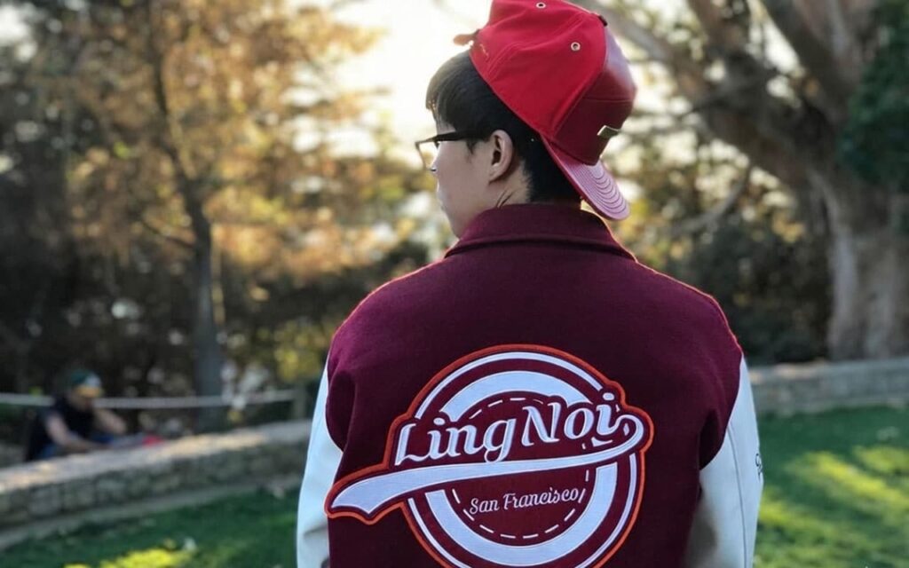 Close-up of retro varsity jacket stripes, letter patch, and snaps
