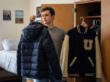Student choosing between a puffer jacket and a varsity jacket