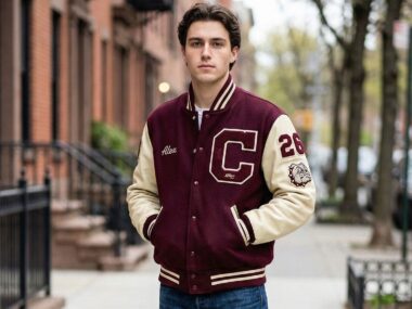 A student wearing custom varsity jacket outside the college with custom patches.