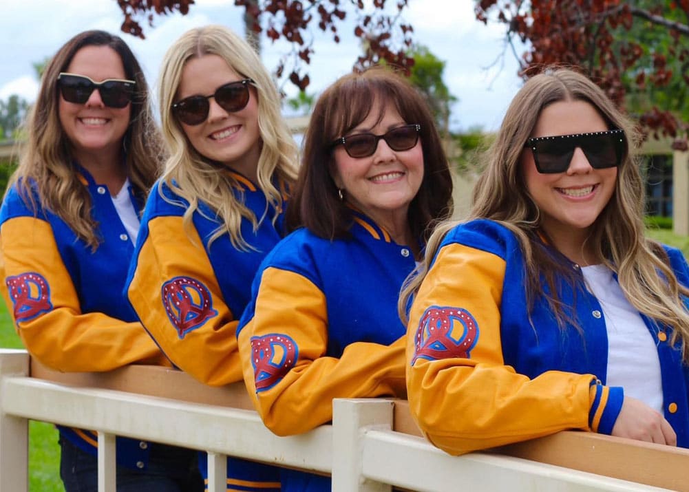 Women marketing group in blue and gold varsity jackets for business promotions